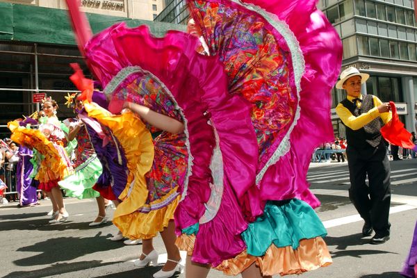 Dancers wearing traditional garb perform for millions of spectators.