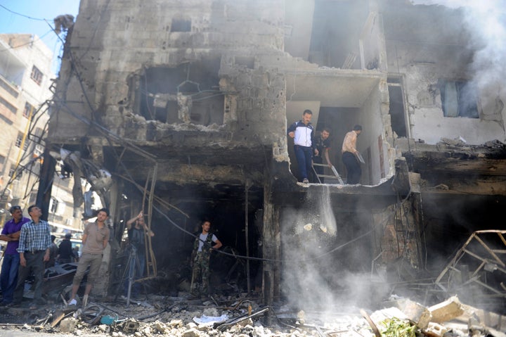 People look at the damage after a suicide and car bomb attack in south Damascus Shi'ite suburb of Sayeda Zeinab.