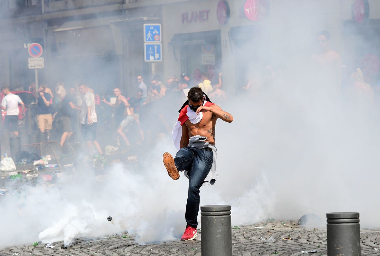 An England fan kicks away a tear gas canister after tear gas was released by French police in the city of Marseille, southern France, on June 11, 2016.