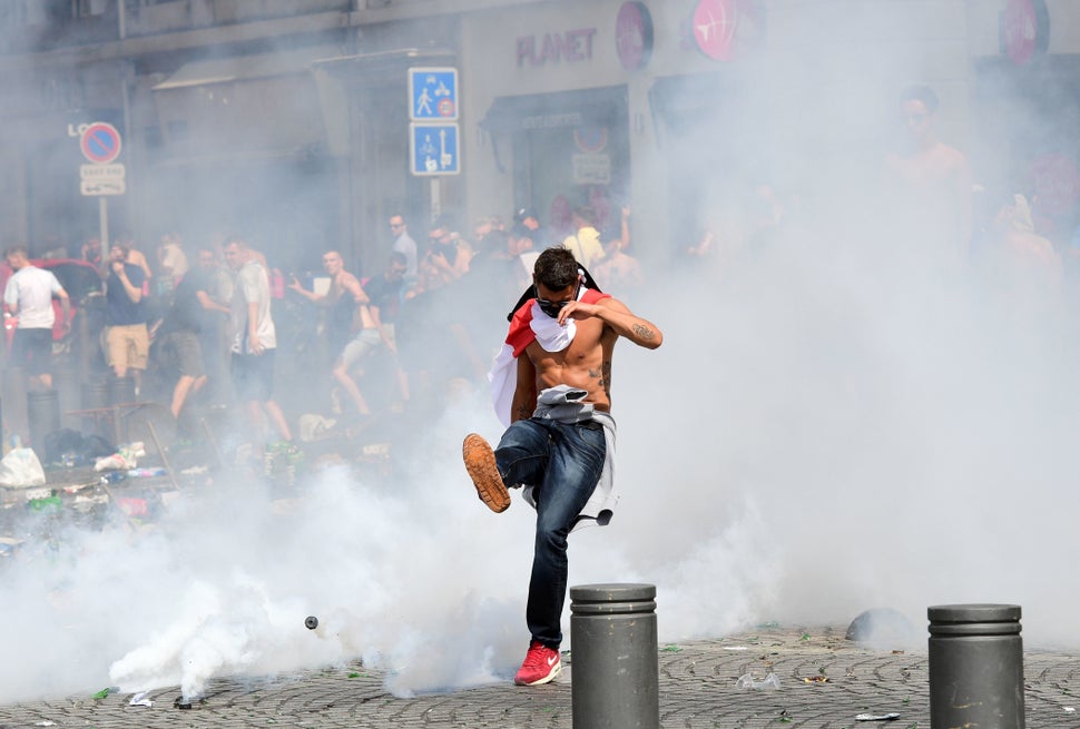 An England fan kicks away a tear gas canister after tear gas was released by French police in the city of Marseille, southern