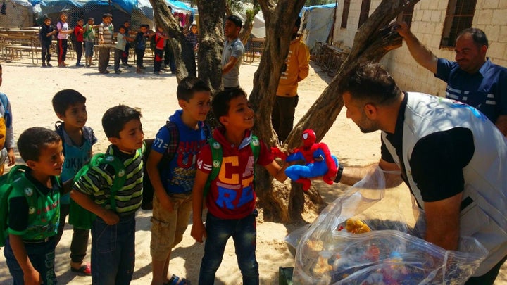 Adham hands out toys at the Atma refugee camp.