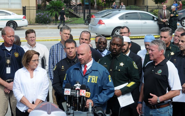 FBI assistant special agent in charge Ron Hopper (C), law enforcement and local community leaders speak during a press confer
