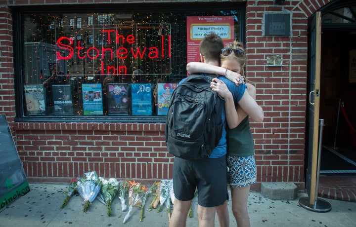 In reaction to the mass shooting, people hug outside the Stonewall Inn near a vigil for the victims.