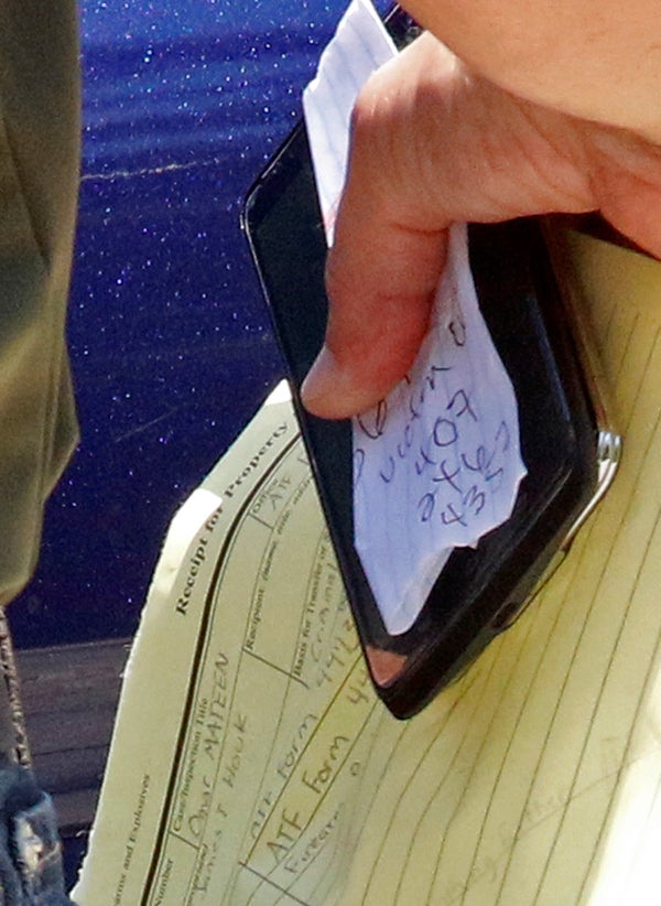 Miami FBI agent Michael Leverock carries an evidence bag and documents to his car outside a condominium complex in Fort Pierc