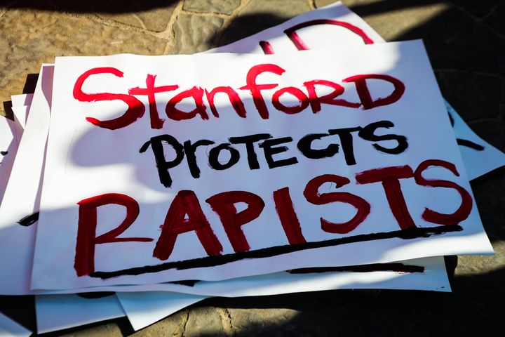 Signs against protecting rapist are seen during the commencement ceremony at Stanford University, in Palo Alto, California, on June 12, 2016. Stanford students are protesting the university's handling of rape cases alleging that the campus keeps secret the names of students found to be responsible for sexual assault and misconduct.