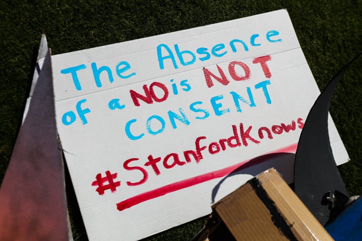 Signs against protecting rapist are seen during the commencement ceremony at Stanford University, in Palo Alto, California, on June 12, 2016.