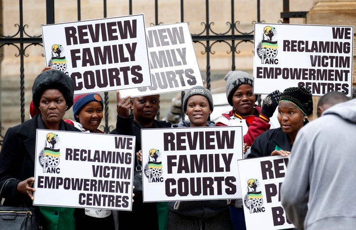 Protesters carry placards during Monday's sentencing at the Pretoria High Court, South Africa.