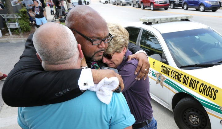 Kelvin Cobaris, a local clergyman, consoles Orlando City Commissioner Patty Sheehan, right, and Terry DeCarlo, an Orlando gay rights advocate, as they arrive on the scene near Pulse nightclub in Orlando on Sunday, June 12, 2016.