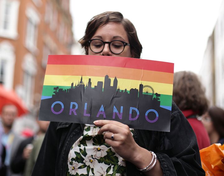 A woman holding an Orlando placard on Old Compton Street, London, during a vigil for the victims