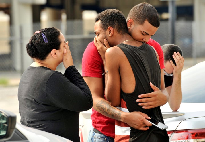 Friends and family members embrace outside the Orlando Police Headquarters in Orlando, Florida, on June 12 after a mass shoot