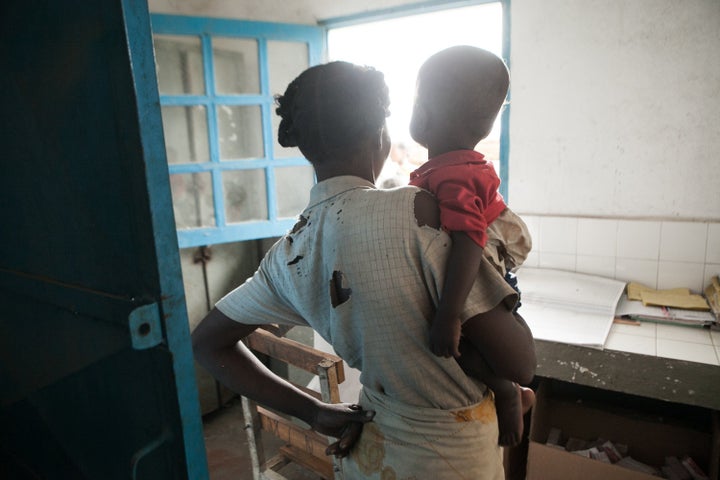 This picture taken on March 4, 2015 shows an undernourished 15-month-old baby and his mother waiting for medications in the v