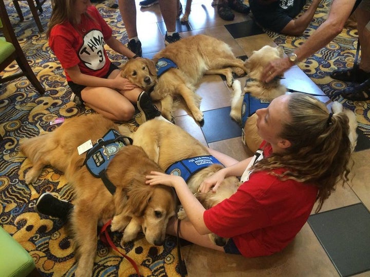 Girls snuggle with a few comfort dogs in Orlando.