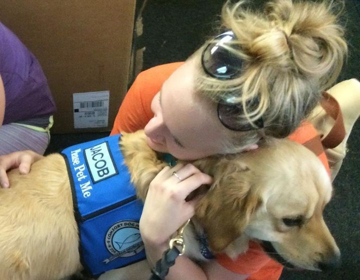 Girl hugs one of the comfort dogs.