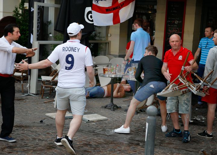 England and Wales fans react after scuffles with Russian supporters outside a bar in Lille.