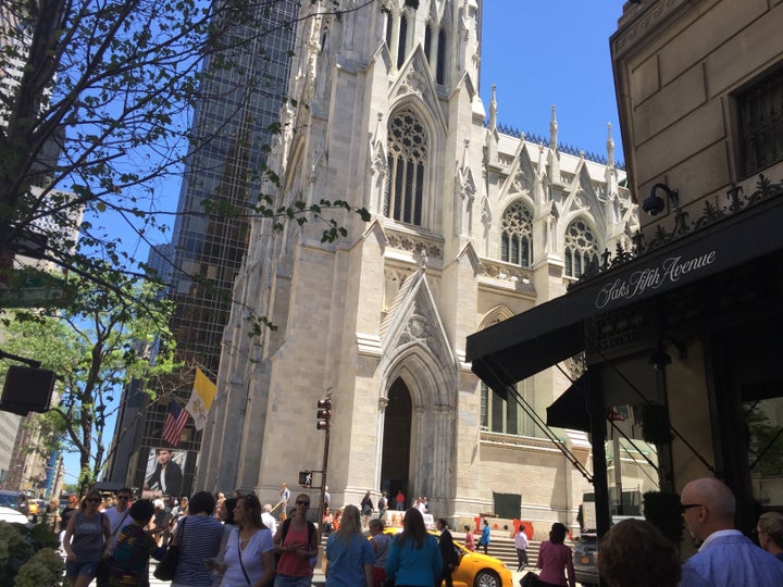 St. Patrick's Cathedral towers over Saks Fifth Avenue in bustling midtown Manhattan.