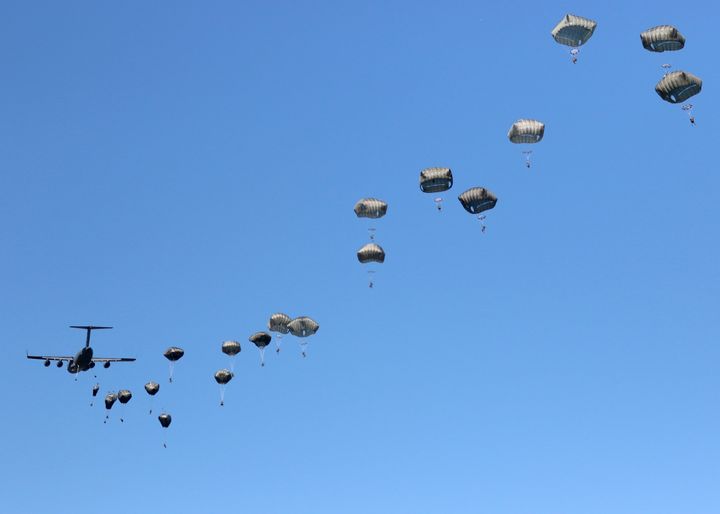A thousand feet above the ground, a C-17 disgorges its paratroopers in a 22-second pass over the drop zone.