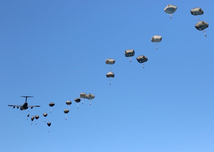 A thousand feet above the ground, a C-17 disgorges its paratroopers in a 22-second pass over the drop zone.