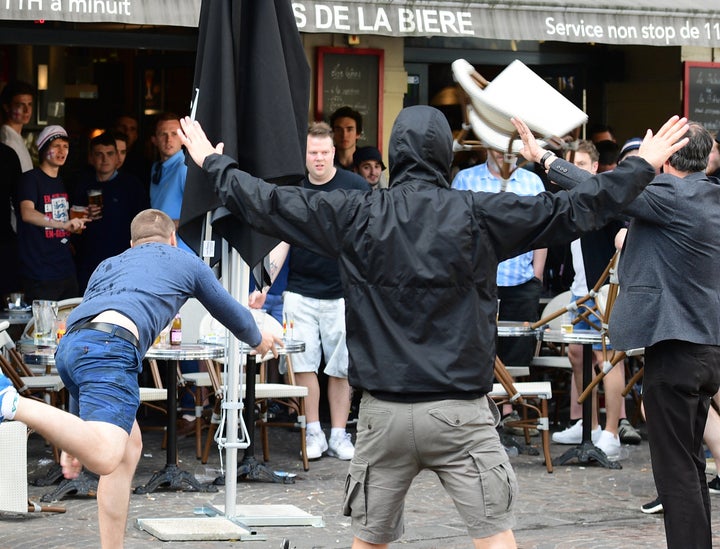 A Russian football supporter lobs a chair towards England fans as violence again kicked off between the groups in Lille