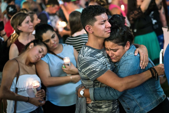 People embrace during a vigil outside the Dr. Phillips Center for the Performing Arts for the mass shooting victims at the Pulse nightclub June 13, 2016 in Orlando, Florida.