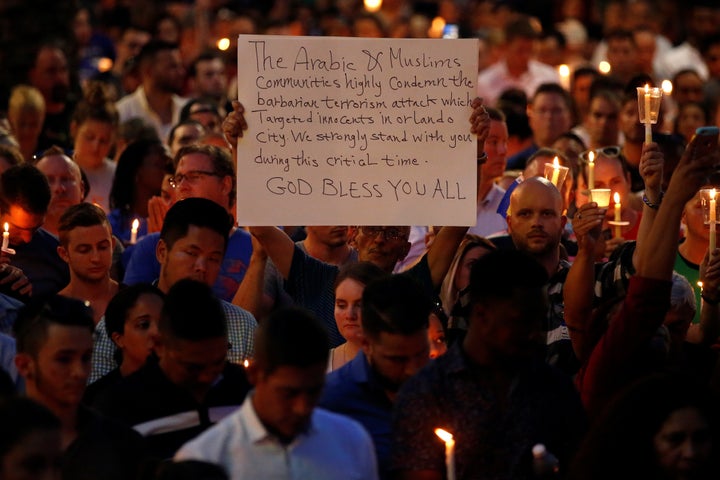 A man holds up a sign saying Arab Muslims condemn the attack on Orlando