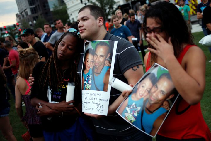 Mourners hold a picture of their deceased friend, Xavier Emanuel Serrano Rosado, during a vigil one day after a mass shooting at the gay Orlando nightclub Pulse. The shooter, Omar Mateen, had a history of domestic violence.