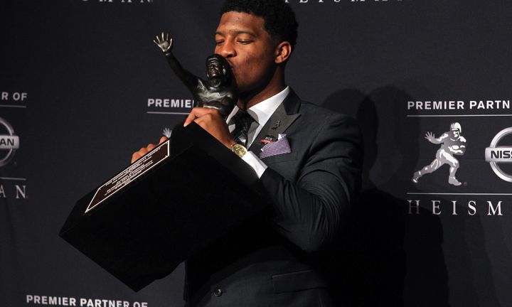 Quarterback Jameis Winston kisses his Heisman Trophy one year after being accused of rape.