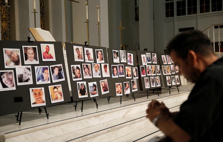 David Olson prays in front of photographs of victims of the shooting at the Pulse gay nightclub, during an Interfaith Service at First United Methodist Church in Orlando, Florida, June 14, 2016.