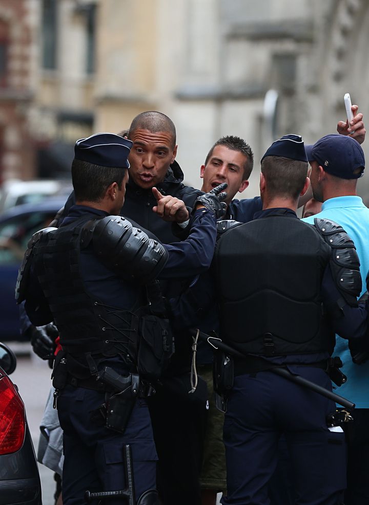 Former footballer Stan Collymore chats to police outside the train station in Lille city centre