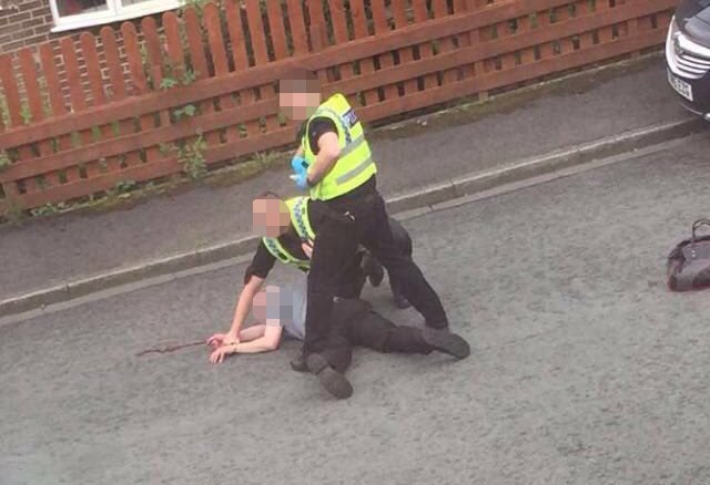 A man being pinned to the ground by police near the scene of the shooting