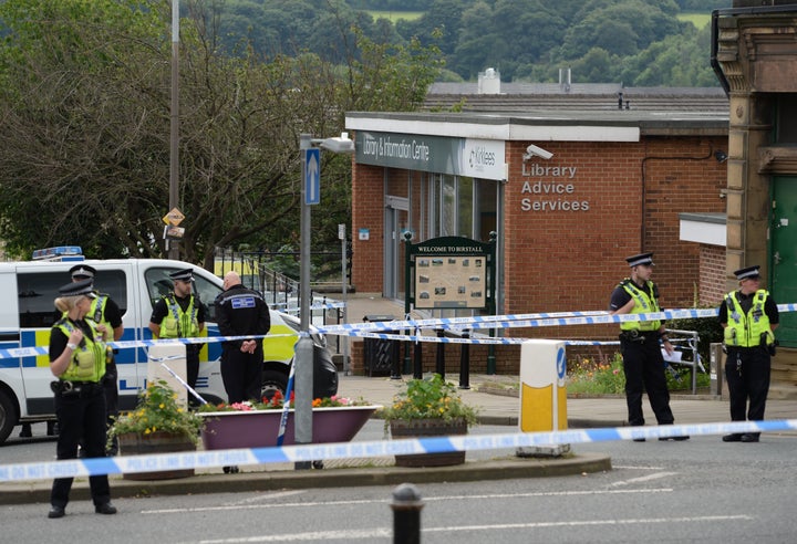 Police stand guard on the perimeter of the crime scene outside the library in Birstall where Jo Cox was shot