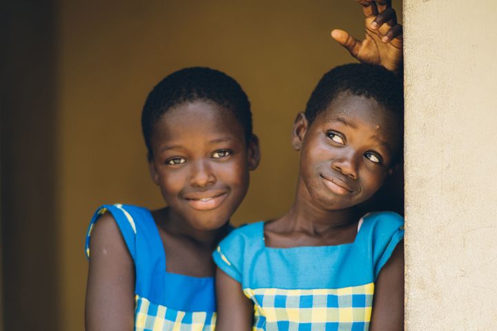 Two young girls take a playful break at the Challenging Heights School, in Ghana.
