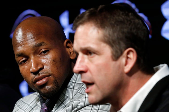 Monroe looks on at Harbaugh during a 2014 press conference announcing Monroe's new Ravens contract. 