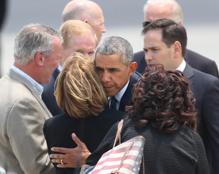 President Obama hugs Orange County Mayor Teresa Jacobs as Orlando Mayor Buddy Dyer watches after Obama arrived at Orlando International Airport on Thursday, June 16, 2016.