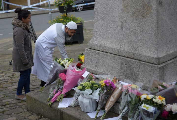 A man lays flowers at a statue in Birstall, northern England, in tribute to 41-year-old lawmaker Jo Cox on Friday.