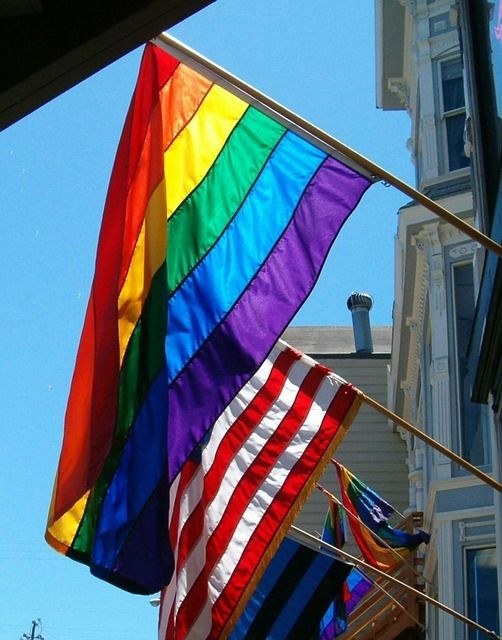 Gay pride flag flying alongside American flag