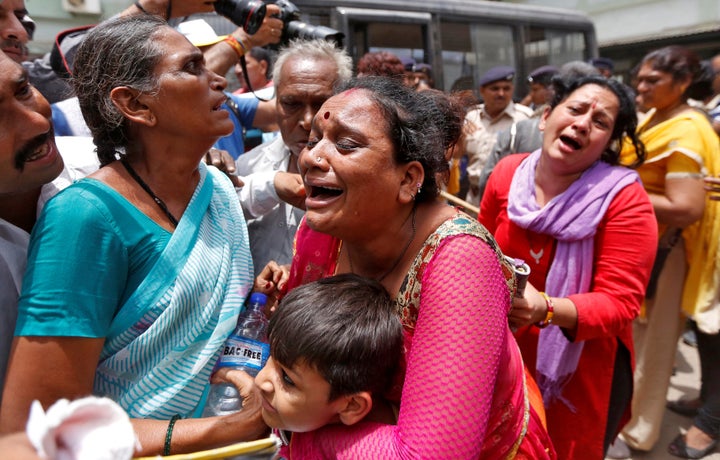 Among the victims of the riot were children and women who were burned to death. Pictured here, relatives of the convicted cry outside a court after the sentencing.