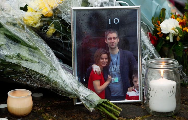 A photo of Jo Cox with her husband Brendan and one of her children, left among floral tributes in Birstall, West Yorkshire