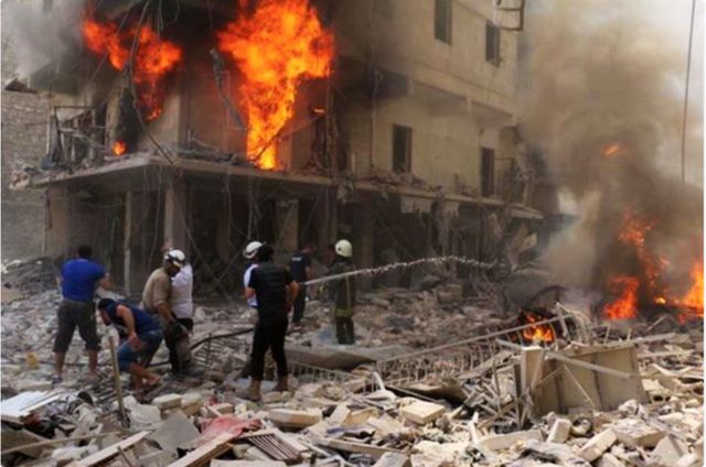 Syrian Civil Defense volunteers respond to the bombing of a residential building in Aleppo city, April 2016.