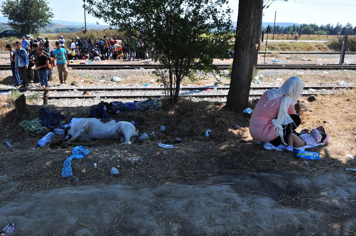 A woman changes her baby's diaper, as migrants wait at the Greek-Macedonian border near the town of Idomeni, Greece.