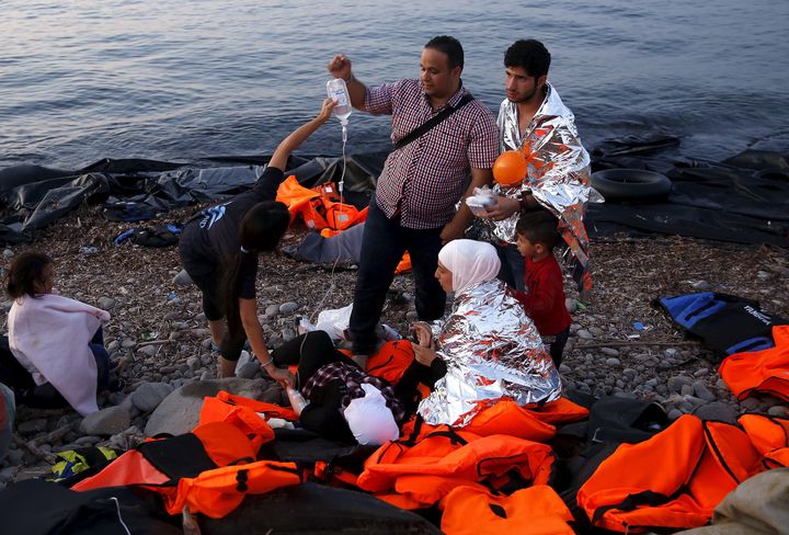 Volunteers provide medical help to a pregnant Syrian refugee woman, shortly after she arrived with her family on a overcrowded dinghy on the Greek island of Lesbos.