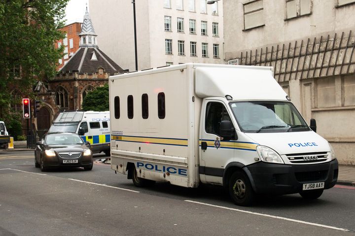Two police cars and police vans arrive at Westminster Magistrates' Court ahead of Thomas Mair's hearing.
