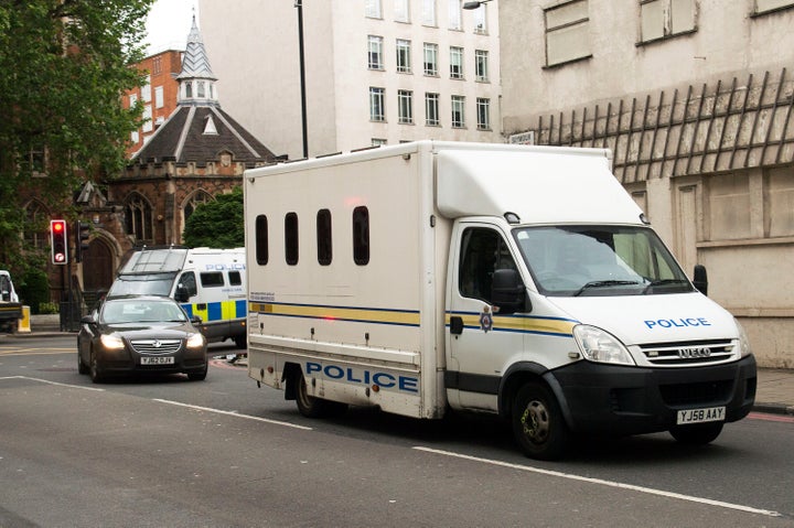 Two police cars and police vans arrive at Westminster Magistrates' Court ahead of Thomas Mair's hearing.