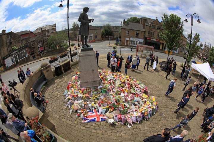 Locals view the growing amount of flowers and tributes to Jo Cox MP in Market Squre, Birstall, on Saturday.