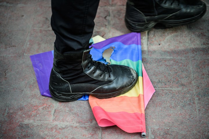 A Turkish anti-riot police officer steps on a rainbow flag during a rally staged by the LGBT community.