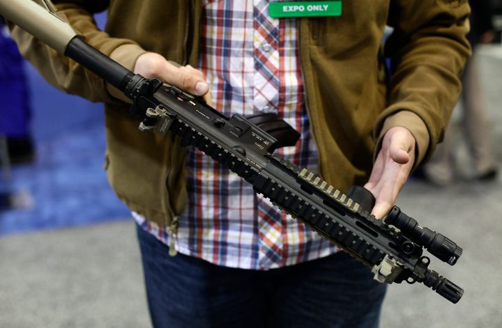 An attendee holds an assault-style weapon at the 7th annual Border Security Expo in Phoenix, Arizona, on March 12, 2013.