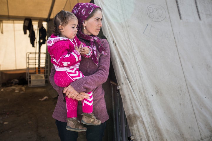 Makbola Kemal Ahmed, a Syrian Kurd from Afrin, stands outside the tent she lived in at Idomeni Camp with her 18-month-old dau
