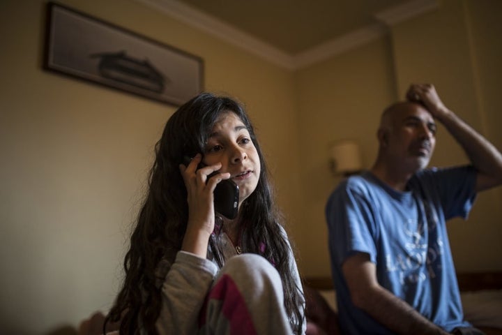 Zeyneb Omer, a 13-year-old Syrian girl from Aleppo, speaks with her mother over Skype, as her father sits nearby. She hasn't