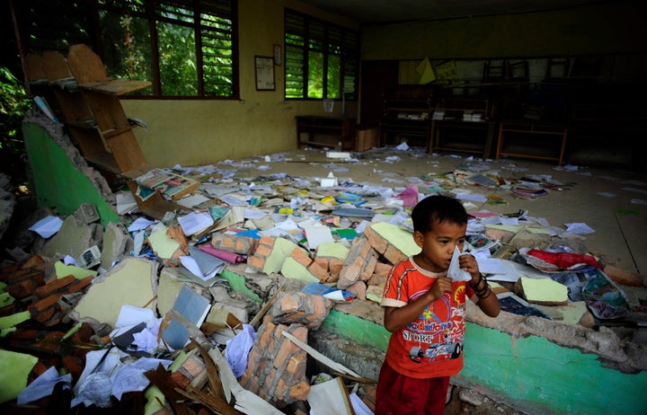 A boy stands outside his earthquake-destroyed classroom at the Timbalun Primary School Number 2 in a village on the outskirts of Padang, Indonesia.