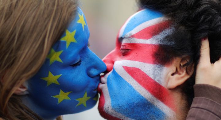Two activists with the EU flag and Union Jack painted on their faces kiss each other in front of Brandenburg Gate to protest against the British exit from the European Union, in Berlin, Germany