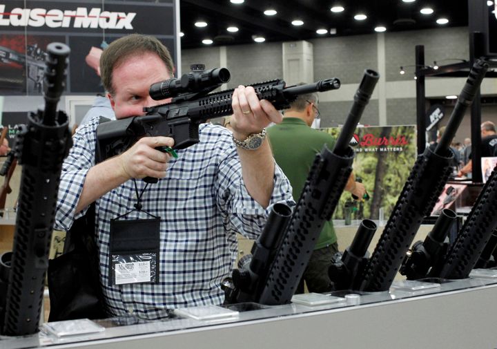 James Bell from Nashville, TN, look over rifle scopes from Burris Riflescope at the National Rifle Association's (NRA) annual meetings and exhibits show in Louisville